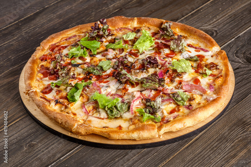 Fresh pizza with tomato sauce, black olives, mozzarella cheese, ham on wooden table closeup. Space for text or copy space. Pizza menu. Restaurant menu advertise