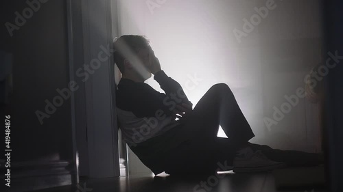 young man crying on floor photo