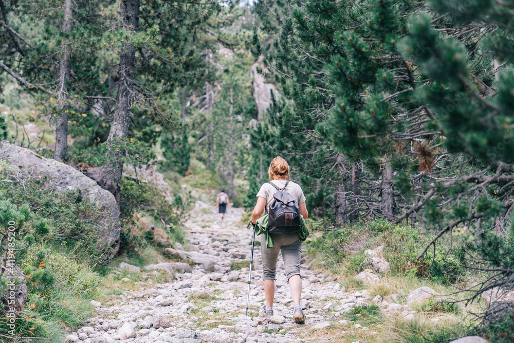 Back view of anonymous backpackers walking on mountain during summer trip Back view of anonymous backpackers walking on mountain during summer trip