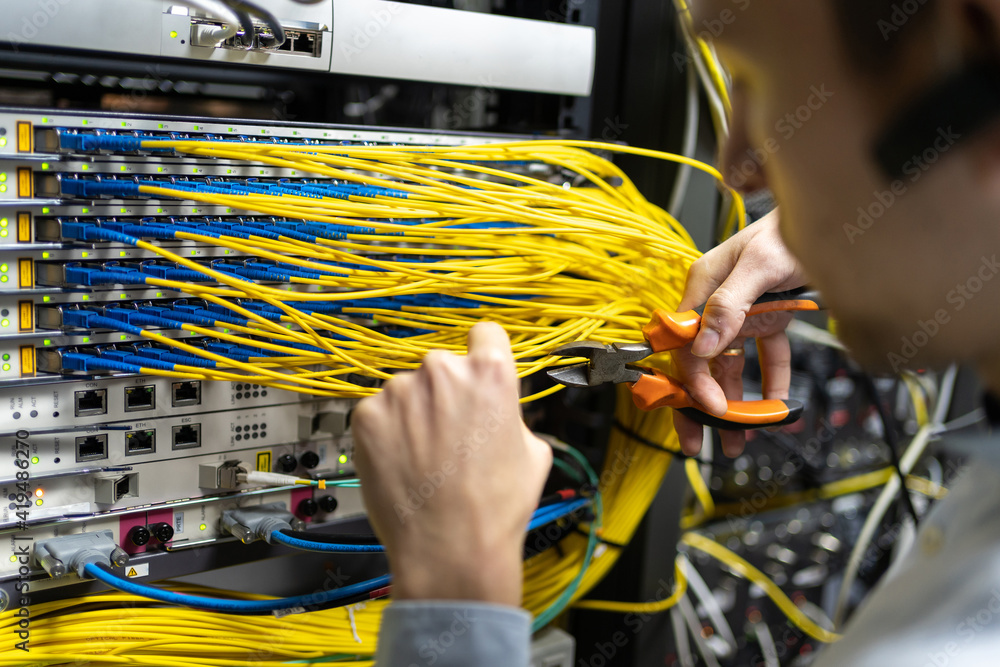 Crop male technician with wire cutters working with electronic system ...