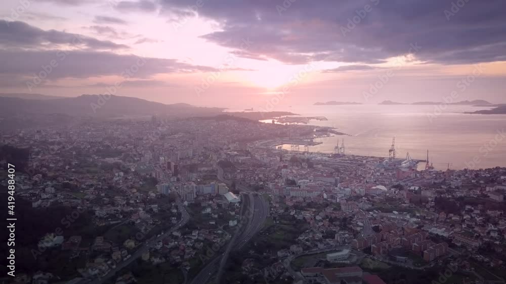 Beautiful aerial sunset view over industrial cityscape at the atlantic coast in Galicia with the Cies island in the background. Drone Stablishing shot in Vigo city. Beautiful aerial sunset view over industrial cityscape at the atlantic coast in Galicia with the Cies island in the background. Drone Stablishing shot in Vigo city.