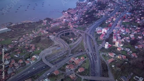 Aerial view of a small highway flyover in Galicia with the atlantic coast and a smal village. Stablishing shot Vigo city. photo