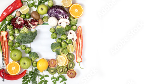 Fresh bright foods with notepad. A strategy for proper and healthy eating. Top view on grocery background