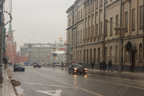Moscow  Russia  Feb 26  2021   Traffic at  Vozdvizhenka street.Towers of the Moscow Kremlin in background
