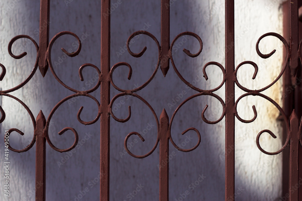 brown wrought iron gate in sunny city - close up, city background brown wrought iron gate in sunny city - close up, city background