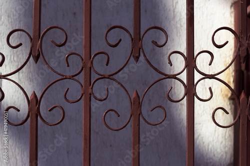 brown wrought iron gate in sunny city - close up, city background