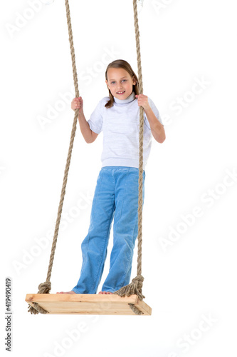 Blonde girl swinging on rope swing