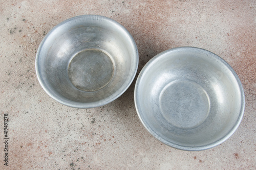 Old metal bowls on concrete background.