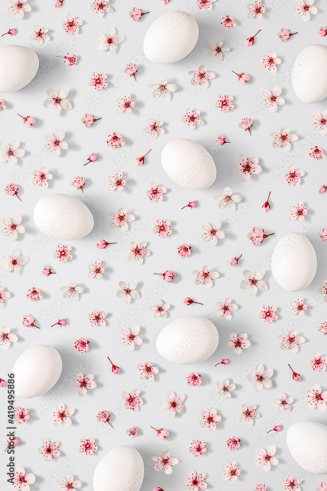 2021 Easter creative layout made with spring flower and white Easter eggs on light grey background. Minimal holiday still life composition. 2021 Easter creative layout made with spring flower and white Easter eggs on light grey background. Minimal holiday still life composition.