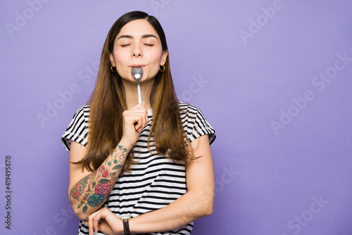 фотографія Latin woman with cravings using a spoon to eat
