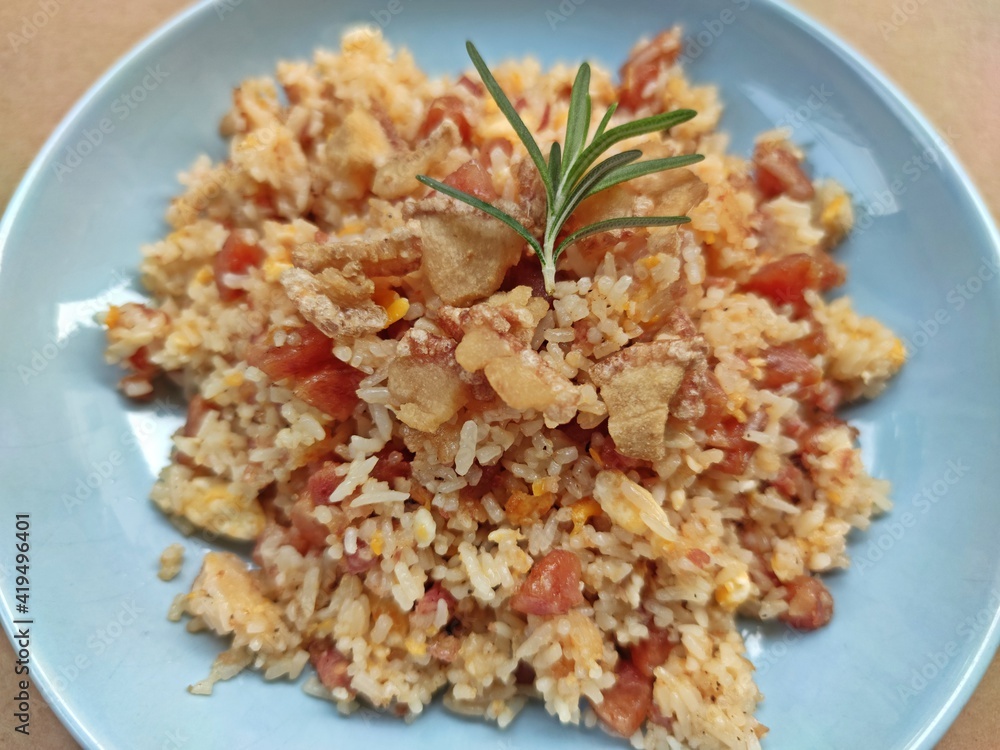 Fried rice with Chinese sausage and fermented pork served in blue plate, Thai food. Selective focus. Fried rice with Chinese sausage and fermented pork served in blue plate, Thai food. Selective focus.