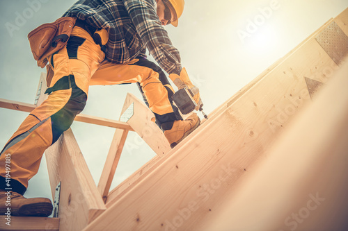 Photo Carpenter Working on Wooden House Frame