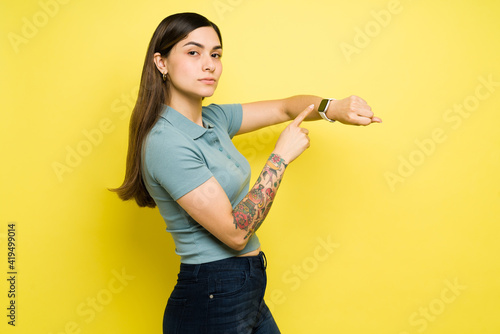 Side view of a beautiful woman pointing to her watch