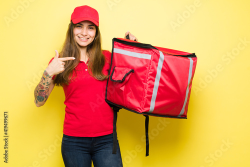 Woman delivery courier smiling and using a backpack