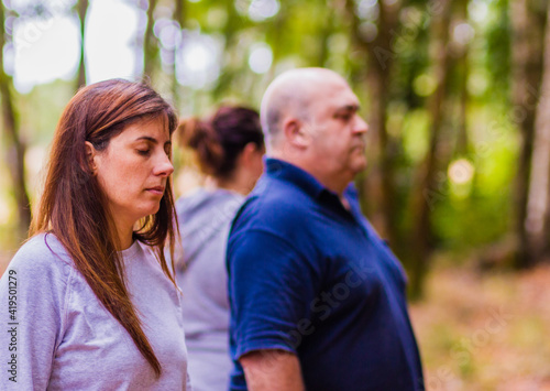 Wellness meditation workshop hispanic adult group relax together with eyes closed in a forest. Breathing in the calm of nature feeling the harmony, health and relieving stress  © Sangiao_Photography