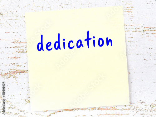 Φωτογραφία Yellow sticky note on wooden wall with handwritten word dedication