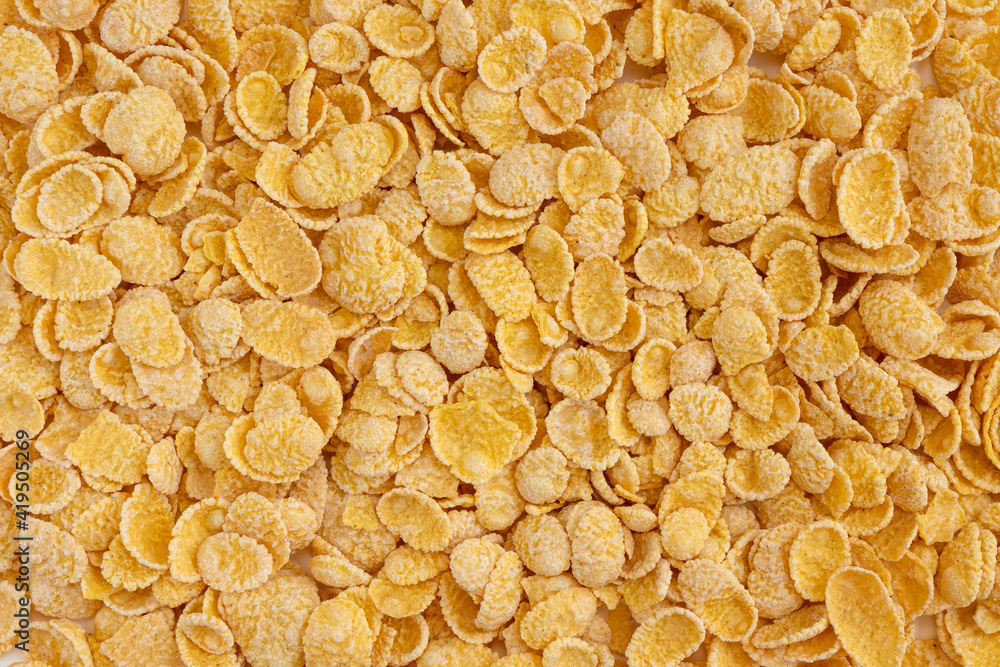 Corn flakes background. Cornflakes scattered on a table. Corn flakes background. Cornflakes scattered on a table.