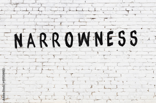 White wall with black paint inscription narrowness on it