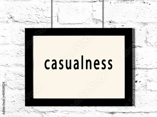 Fotografie Black frame hanging on white brick wall with inscription casualness