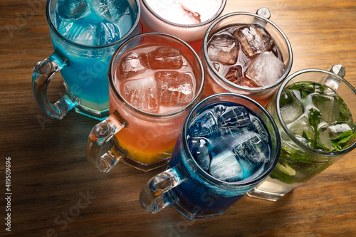 Colorful toned cocktails on wooden background. Frutal alcoholic cocktails. Colorful drinks concept.