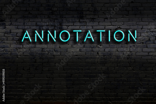 Neon sign. Word annotation against brick wall. Night view