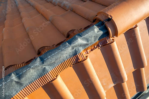 Canvastavla Closeup of yellow ceramic roofing ridge tiles on top of residential building roof under construction