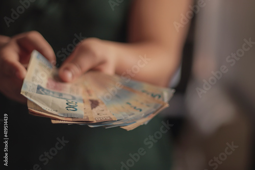 Close up of woman showing 500 Mexican peso bills.