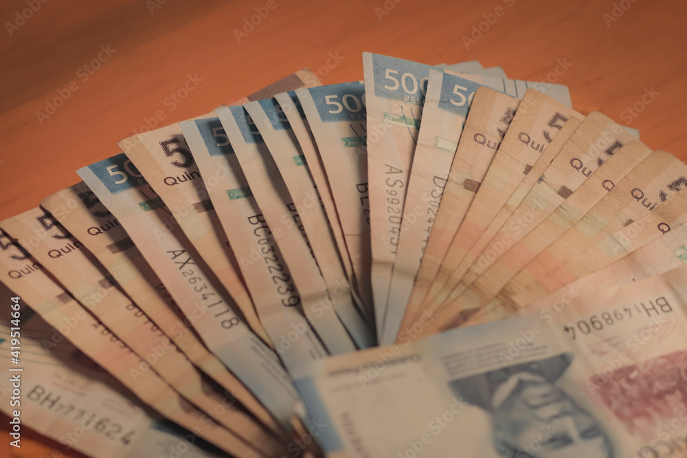 Close up of 500 Mexican peso bills arranged on a wooden table. Close up of 500 Mexican peso bills arranged on a wooden table.