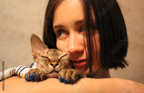 A girl hugs a Canadian Sphynx cat, relationship between human and pet concept.