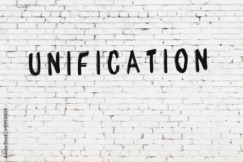White wall with black paint inscription unification on it