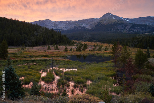 Serene landscape in San Isabel National Forest with the sunset reflecting off of a marsh. photo