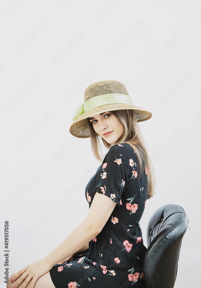 girl in a sundress and straw hat posing on a light, solid background girl in a sundress and straw hat posing on a light, solid background