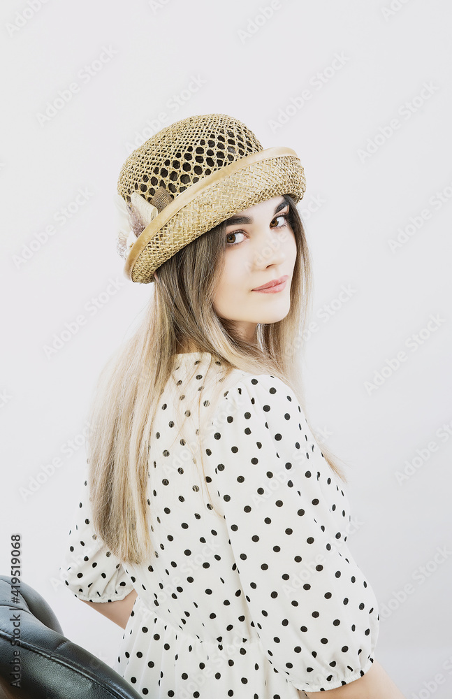 girl in a sundress and straw hat posing on a light, solid background girl in a sundress and straw hat posing on a light, solid background