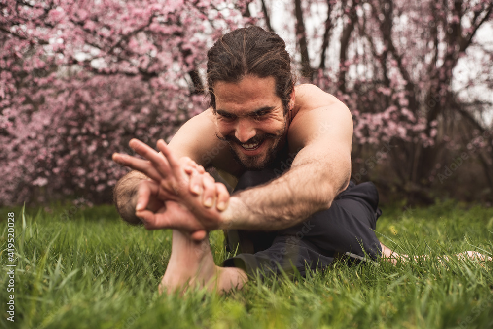 Young man stretching for a yoga session in the park. Fitness, healthy habits and wellness concepts. Young man stretching for a yoga session in the park. Fitness, healthy habits and wellness concepts.