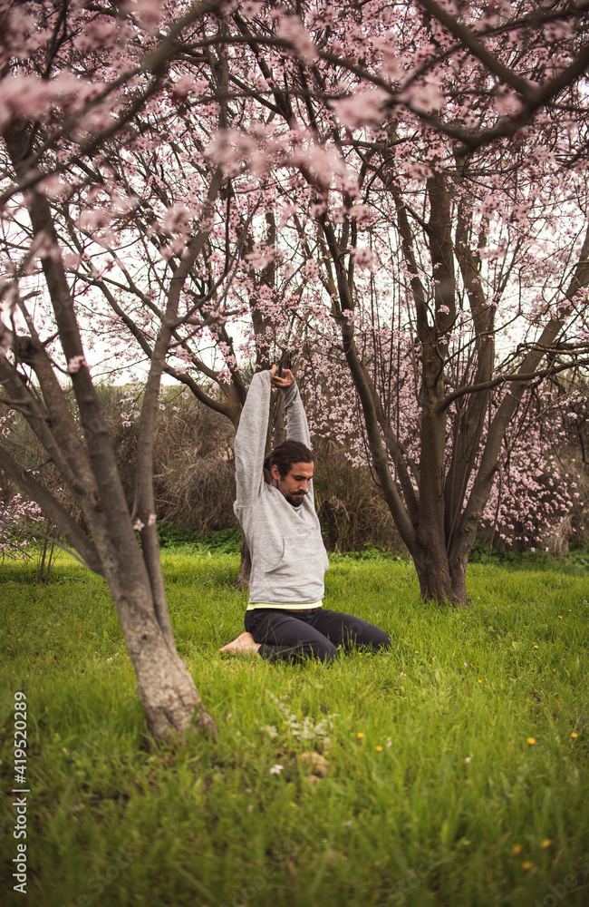 Young man stretching for a yoga session in the park. Fitness, healthy habits and wellness concepts. Young man stretching for a yoga session in the park. Fitness, healthy habits and wellness concepts.