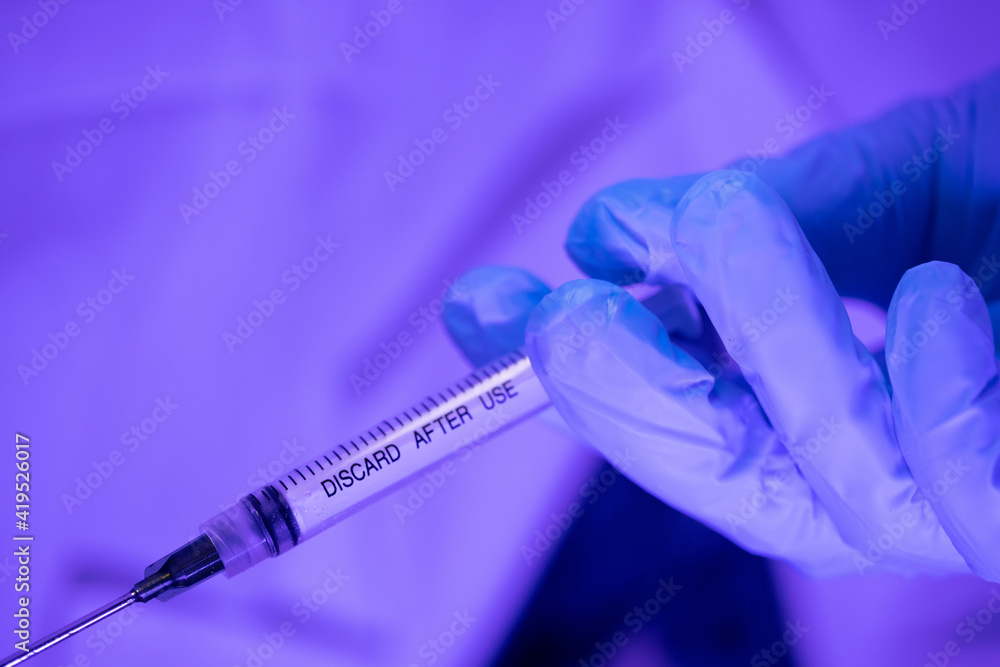 Doctor injecting single use needle - extreme close up Doctor injecting single use needle - extreme close up