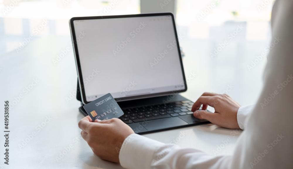 girl makes a purchase on the Internet on the smart tablet with credit card - online shopping concept. girl makes a purchase on the Internet on the smart tablet with credit card - online shopping concept.