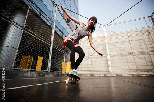 young asian skateboarder skateboarding outdoors