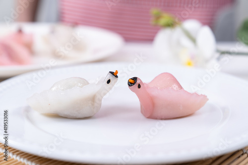 Two Chinese Har Gao Dim Sum dumplings in the shape of a swan, red and white color photo