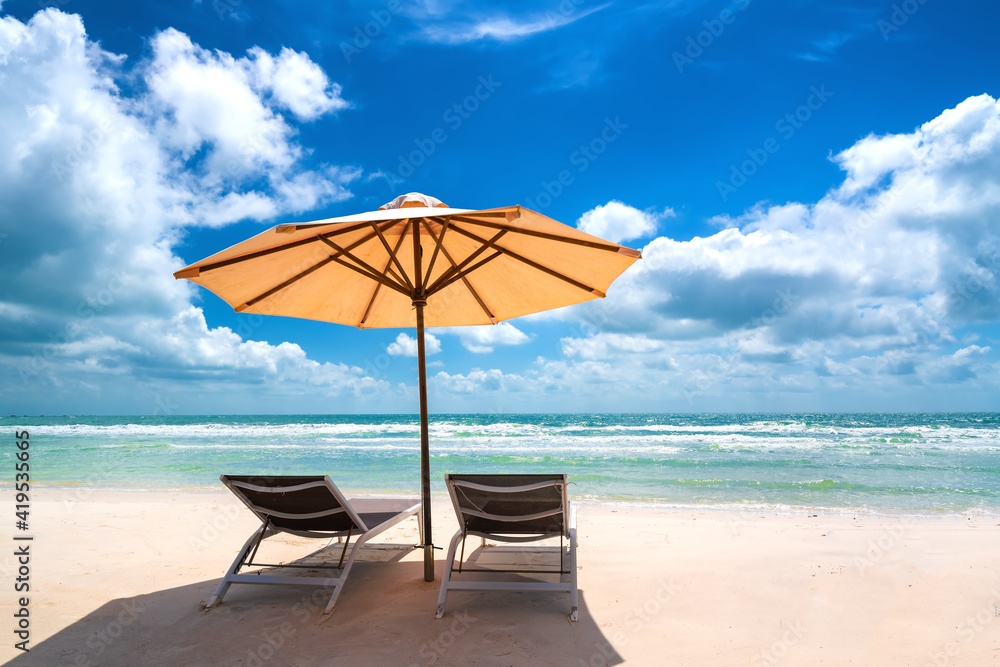 Fototapeta premium Sunbeds under tropical palms on beach on Phu Quoc island, Vietnam. Beach's smile