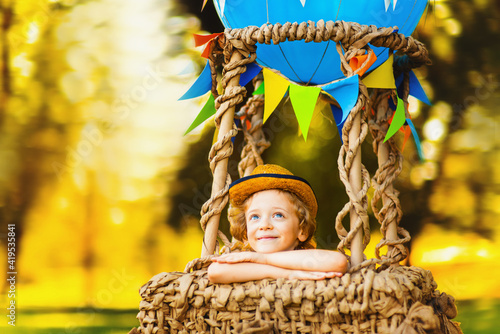 Tableau sur toile Little curly-haired boy in the air dreaming looks into the sky
