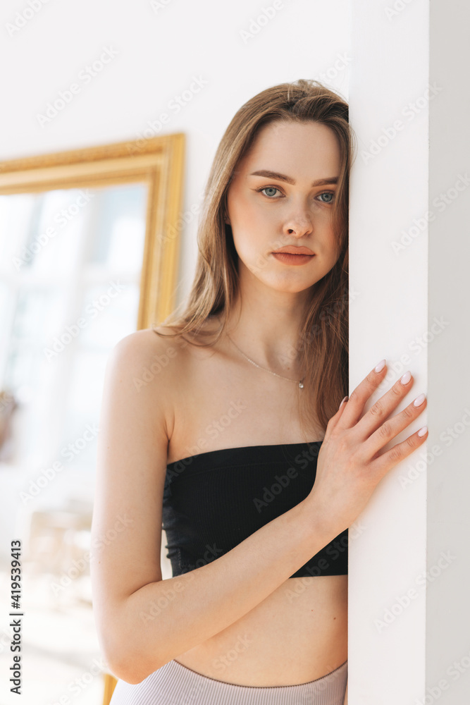 Beautiful young woman beauty fashion model with long hair in sport seamless ribbed underwear looking at camera in bright studio Beautiful young woman beauty fashion model with long hair in sport seamless ribbed underwear looking at camera in bright studio