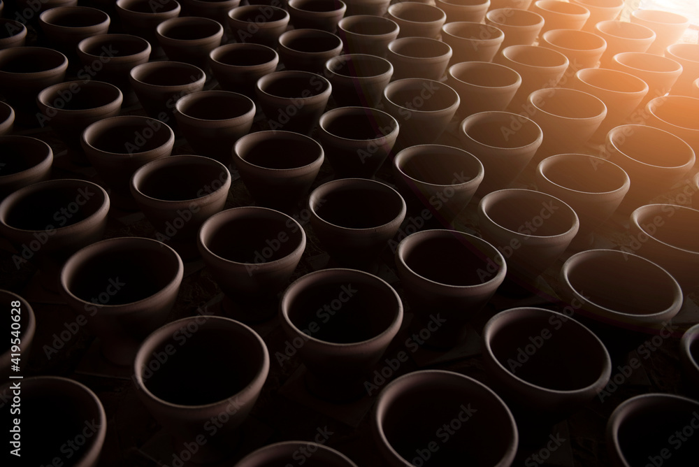 A narrow depth-of-field, blurred background and a large traditional indigenous pottery jar sits side-by-side in an Asian stone mortar pottery. A narrow depth-of-field, blurred background and a large traditional indigenous pottery jar sits side-by-side in an Asian stone mortar pottery.