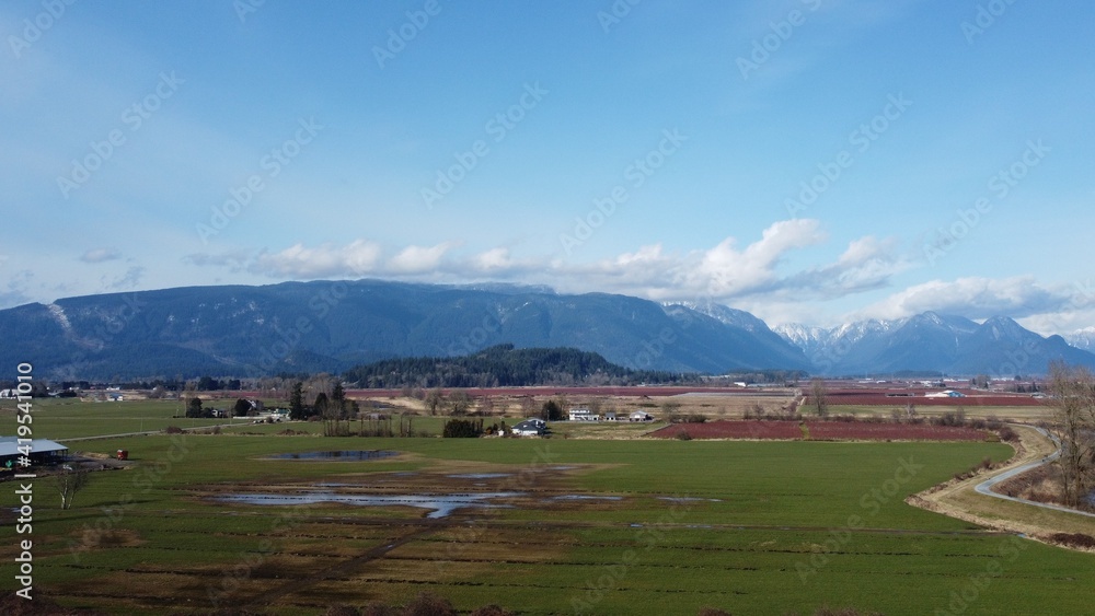 Fototapeta premium Drone shot of Farmland back by mountains