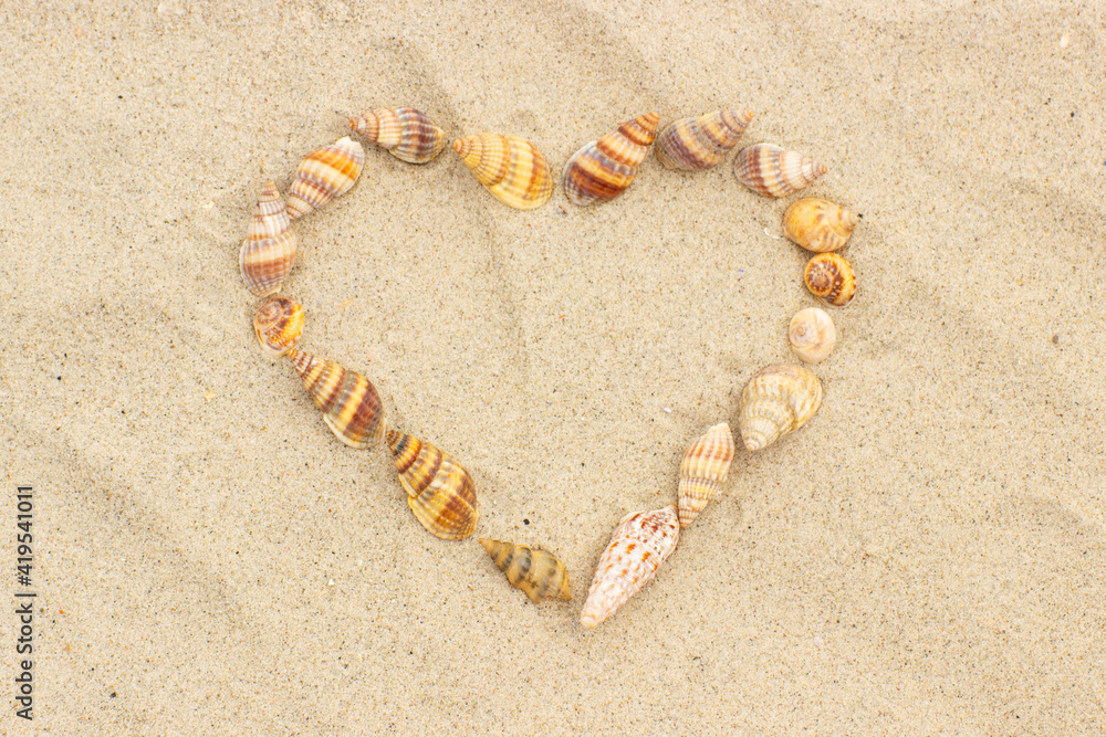 Heart of shells on sand at beach, symbol of love Heart of shells on sand at beach, symbol of love