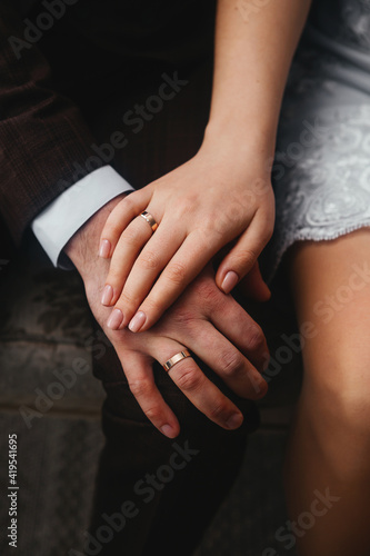 The hands of the newlyweds. The bride and groom got married and, holding hands, showed their wedding rings.