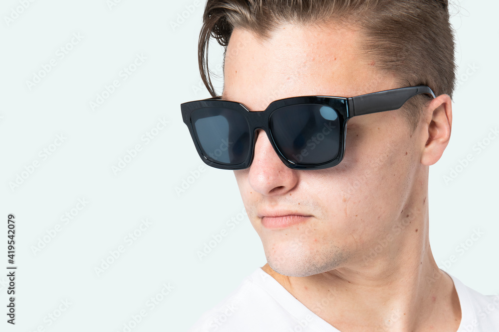 Handsome man wearing black wayfarer sunglasses close up Handsome man wearing black wayfarer sunglasses close up
