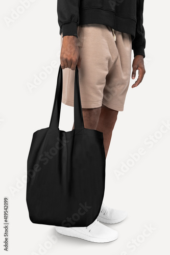 Man carrying black tote bag studio shoot