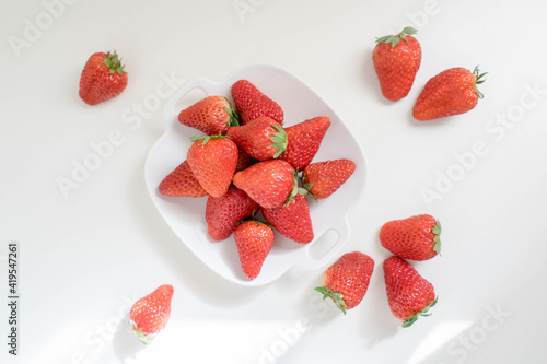 red strawberries in plate on the white table
