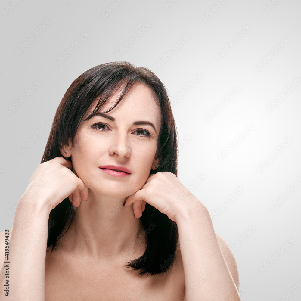 Portrait of beautiful happy mature woman on white studio background